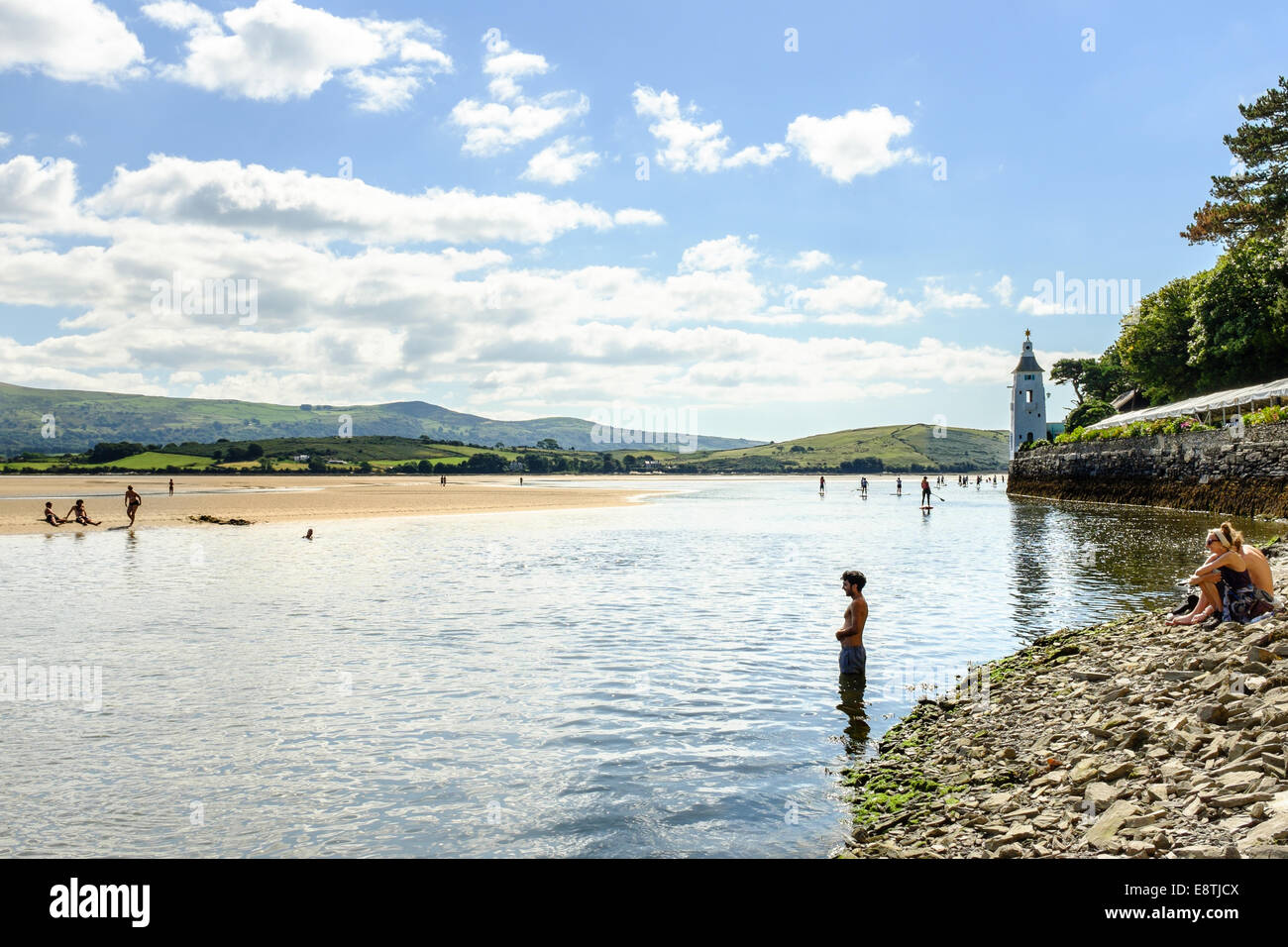 L'uomo entra fiume Dwyryd, nella distanza Paddle Boarders (cortesia di Volvo Cars sponsorizzazione) sull'estuario, il 7 settembre 2014 Foto Stock