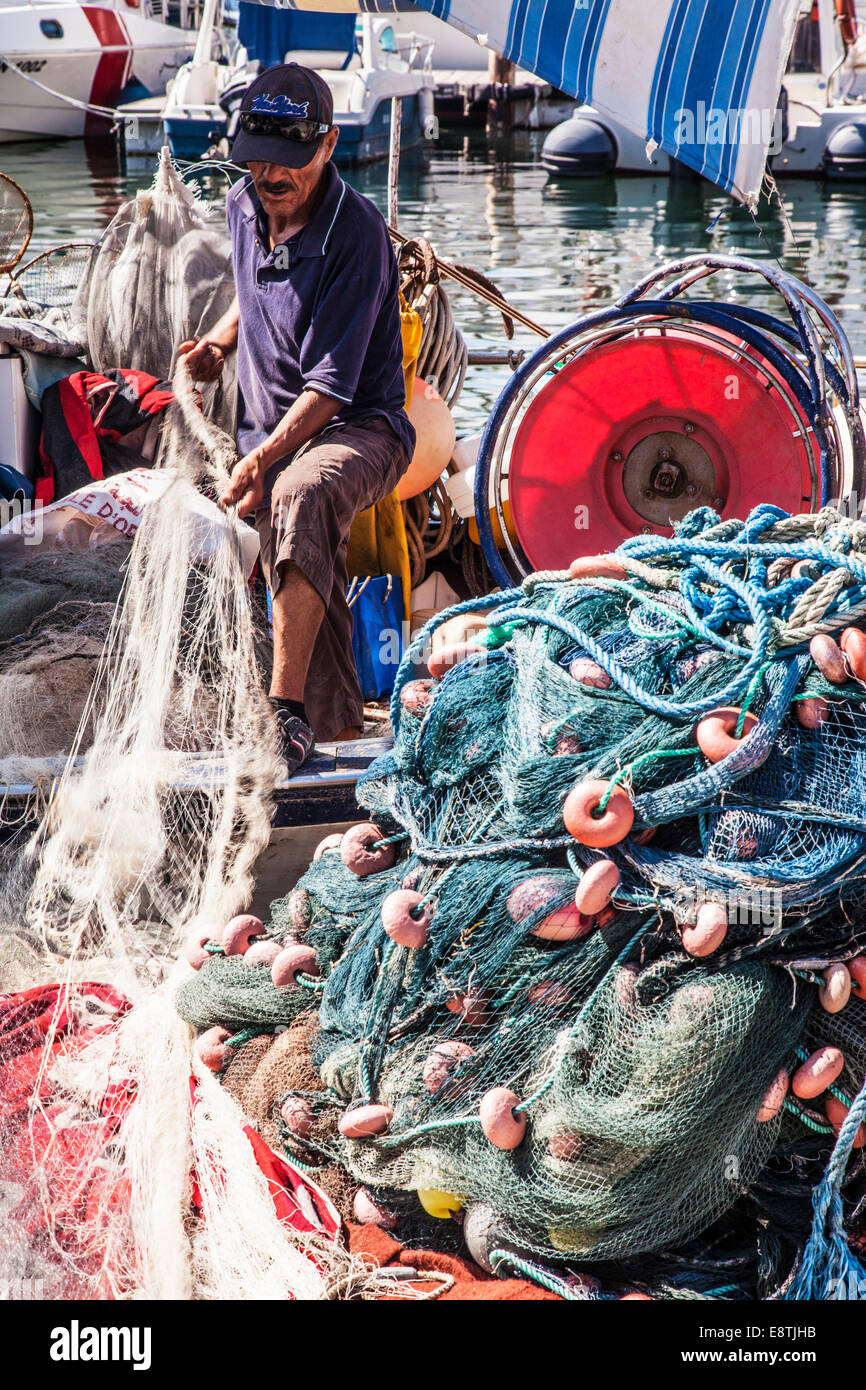 Un pescatore tendendo le sue reti a Port el Kantoui in Tunisia. Foto Stock