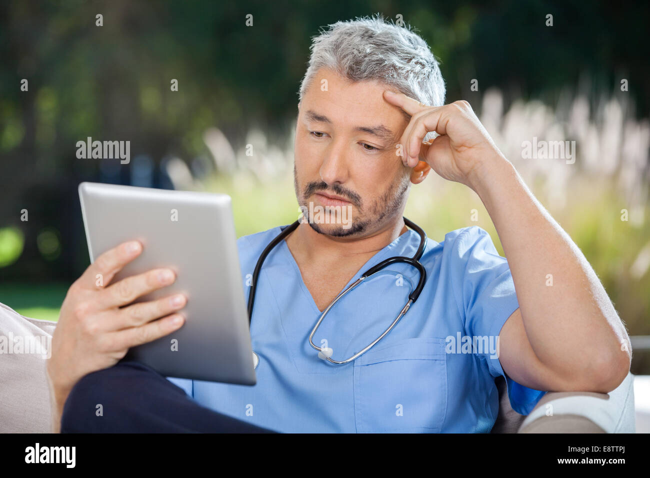 Medico maschio utilizzando un tablet pc Foto Stock