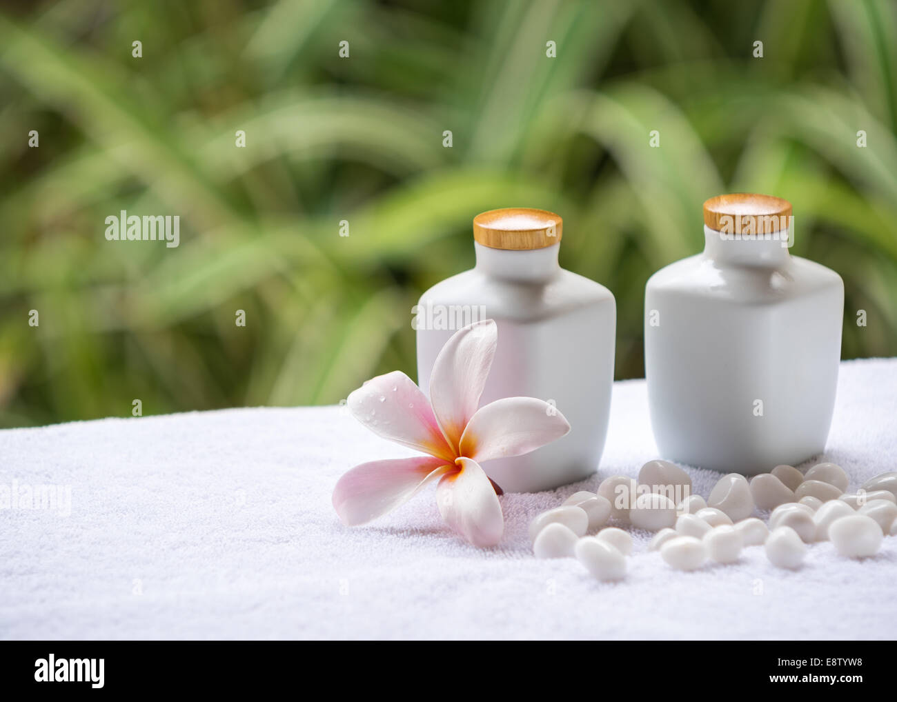 Spa e wellness impostazione con sapone naturale, pietre e asciugamano sullo sfondo verde . Concetto spa. Foto Stock