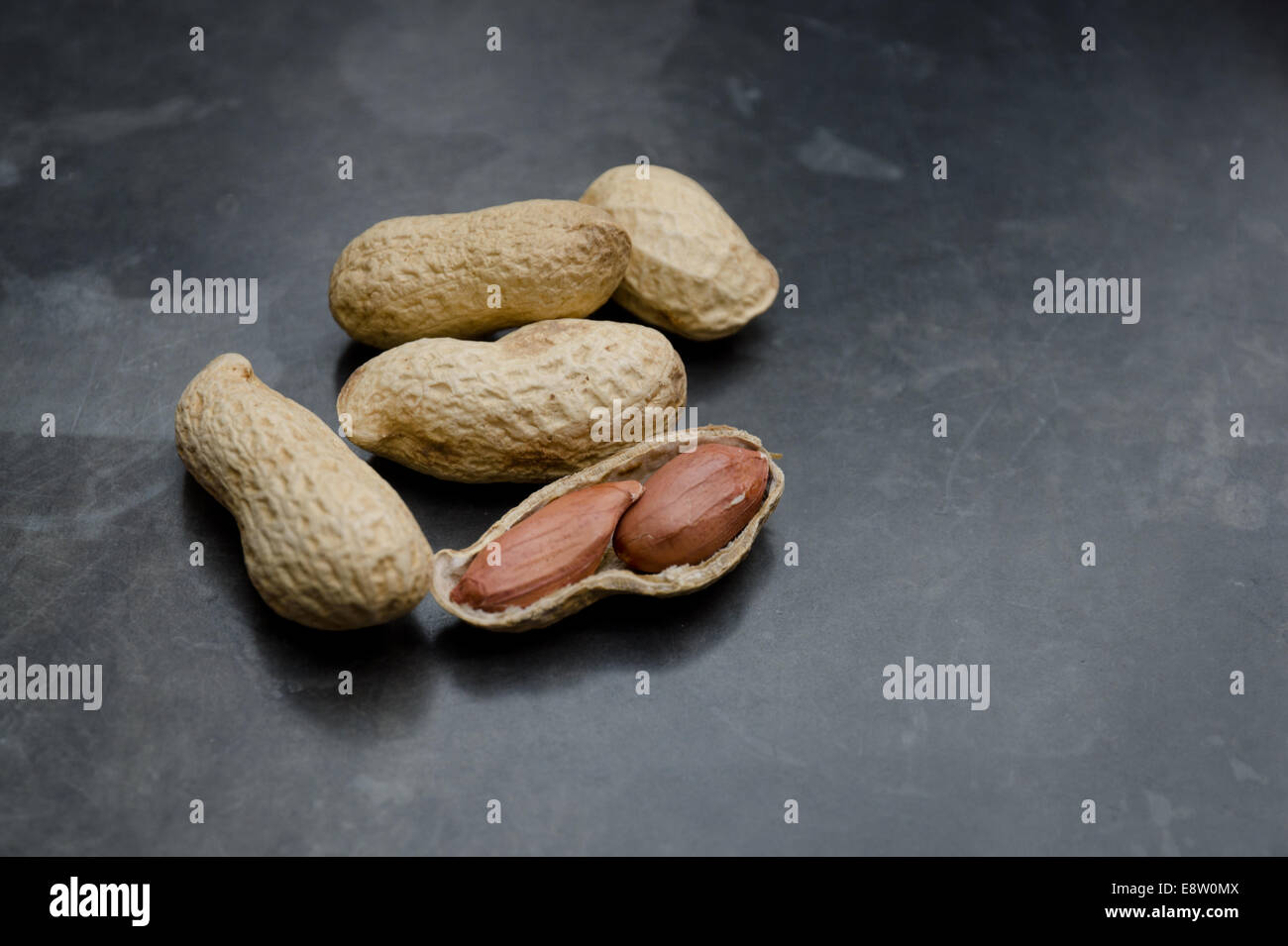 I dadi di scimmia, arachidi, noci di terra, nei loro gusci su un sfondo di ardesia Foto Stock