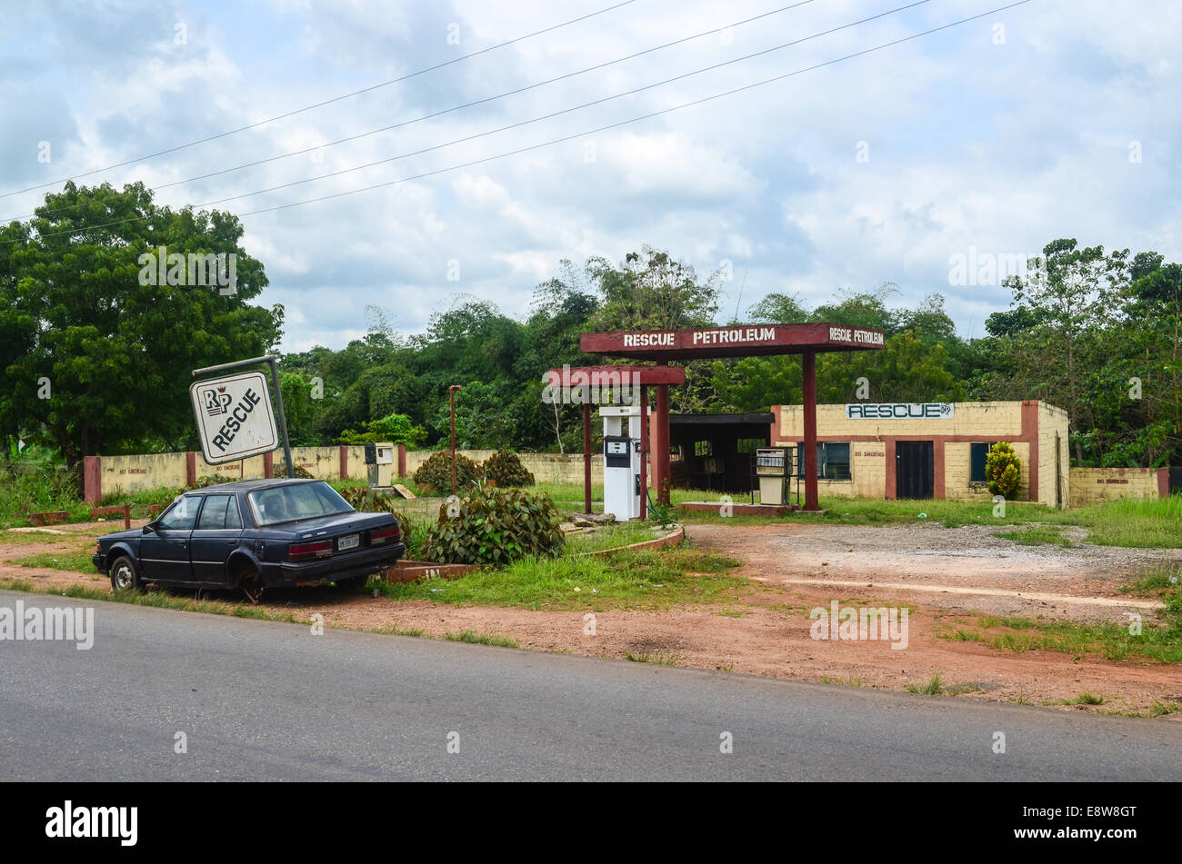 Un abbandonata la stazione di gas nel sud-ovest della Nigeria la lettura di 'rescue' di petrolio e un auto rottamata Foto Stock