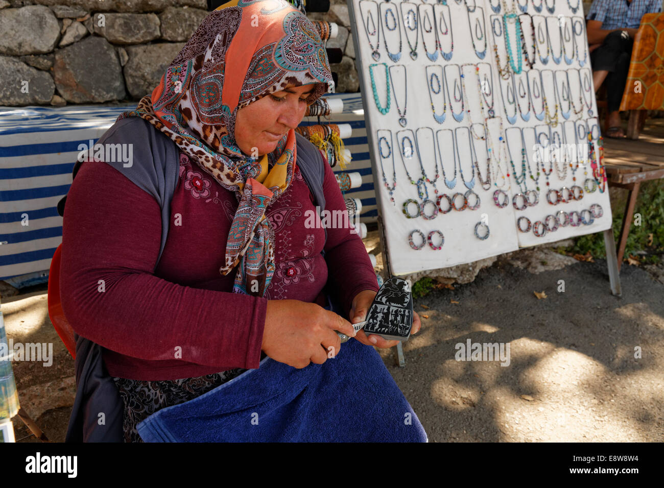 Donna carving una pietra, antica città di Tlos nella valle Xanthos, Muğla Provincia, Lycia, Egeo, Turchia Foto Stock