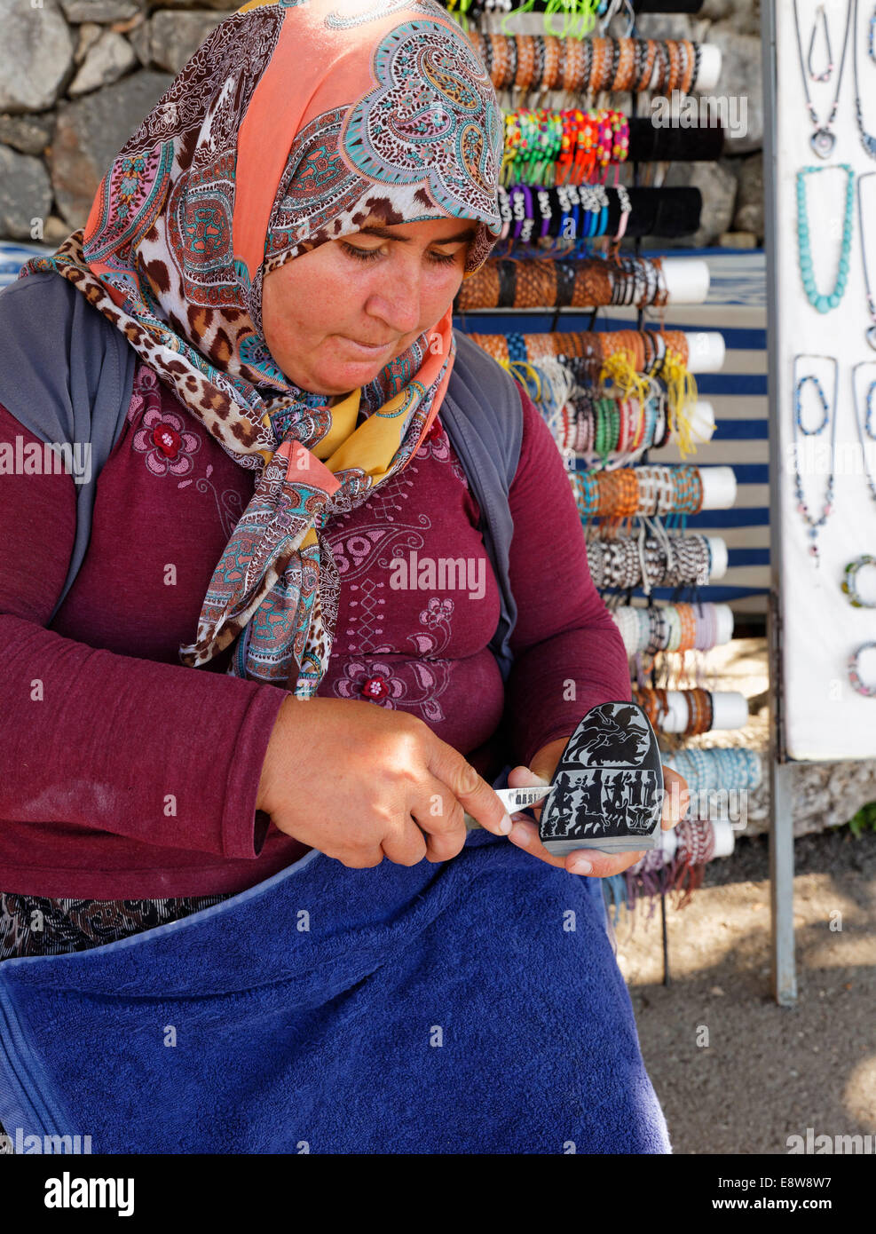 Donna carving una pietra, antica città di Tlos nella valle Xanthos, Muğla Provincia, Lycia, Egeo, Turchia Foto Stock