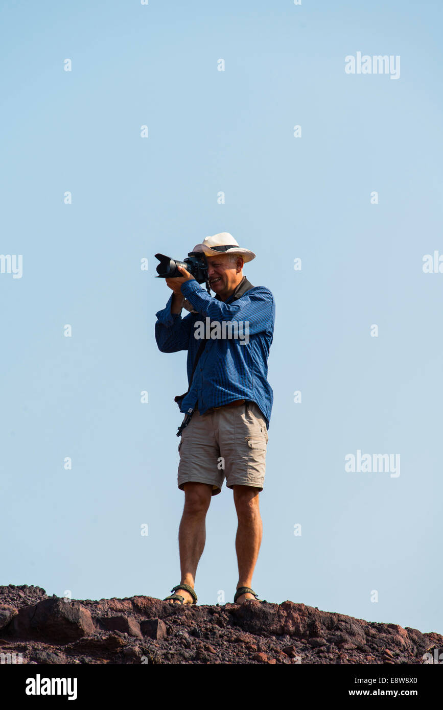 Uomo di scattare una foto in piedi su una roccia, Namibia Foto Stock