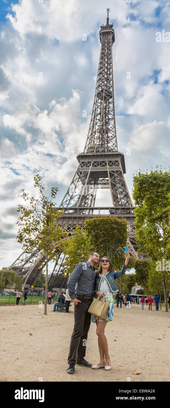 Giovane coppia felice prendendo un selfie vicino alla Torre Eiffel a Parigi. Foto Stock