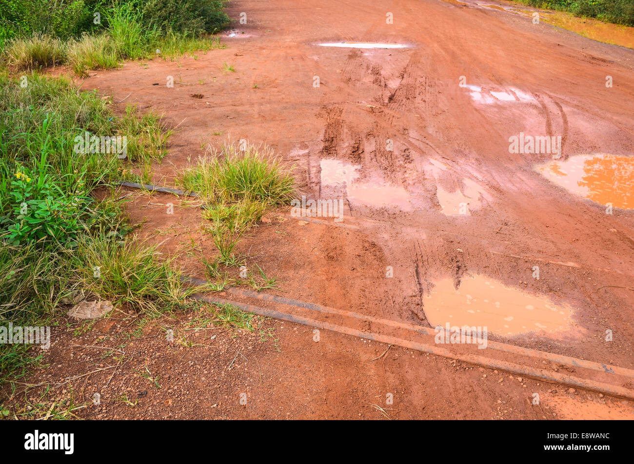 Sterrati fangosi in Nigeria durante la stagione piovosa e abbandonati dalla vecchia linea ferroviaria tra le pozze allagate Foto Stock