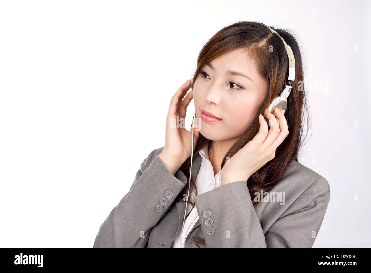 Business donna indossa le cuffie per ascoltare musica Foto Stock