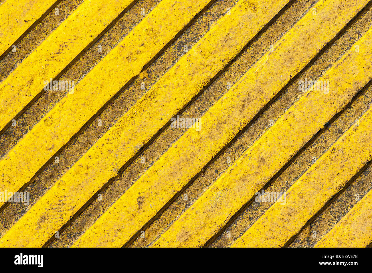 Pavimentazioni tattili bramma texture. Una piastrella di colore giallo con sollevate le linee diagonali Foto Stock