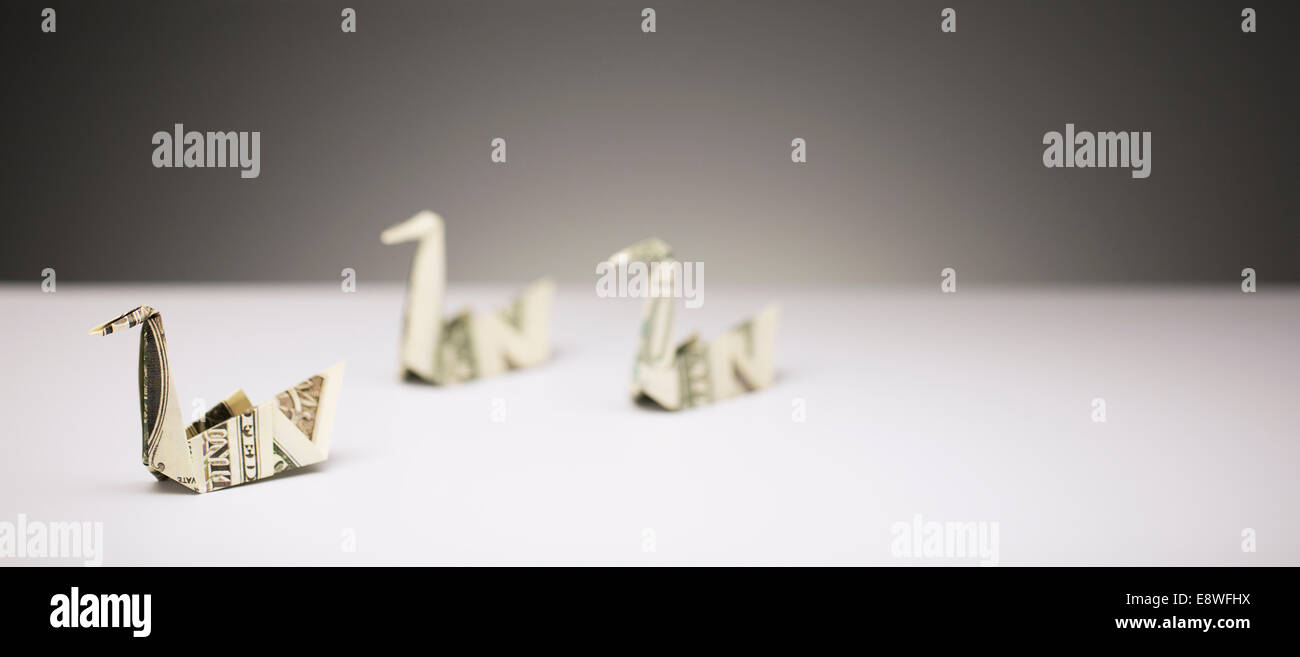 Origami cigni fatta di fatture del dollaro sul contatore Foto Stock