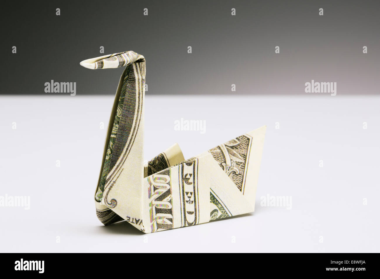 Origami swan fatta di dollari sul contatore Foto Stock