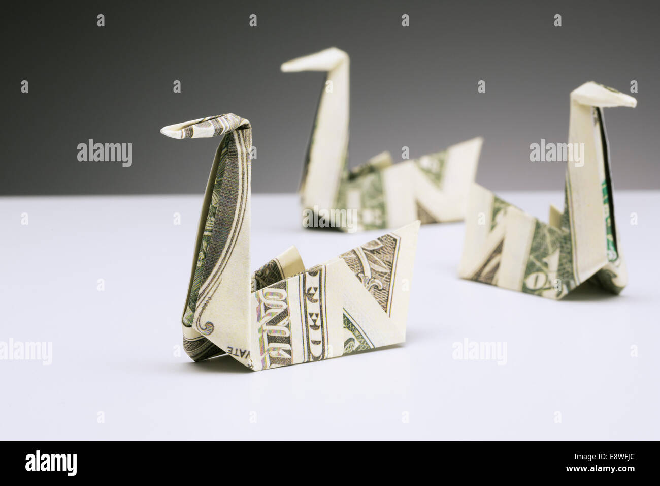 Origami cigni fatta di fatture del dollaro sul contatore Foto Stock