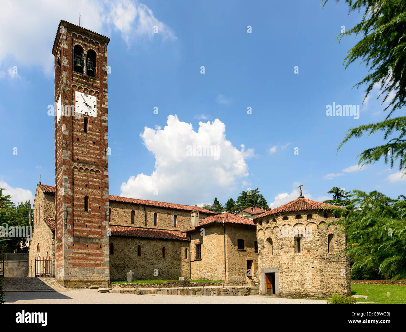 Vista da sud ovest della antica chiesa romanica in Brianza della regione, vicino a Milano, girato in condizioni di intensa luce estiva Foto Stock
