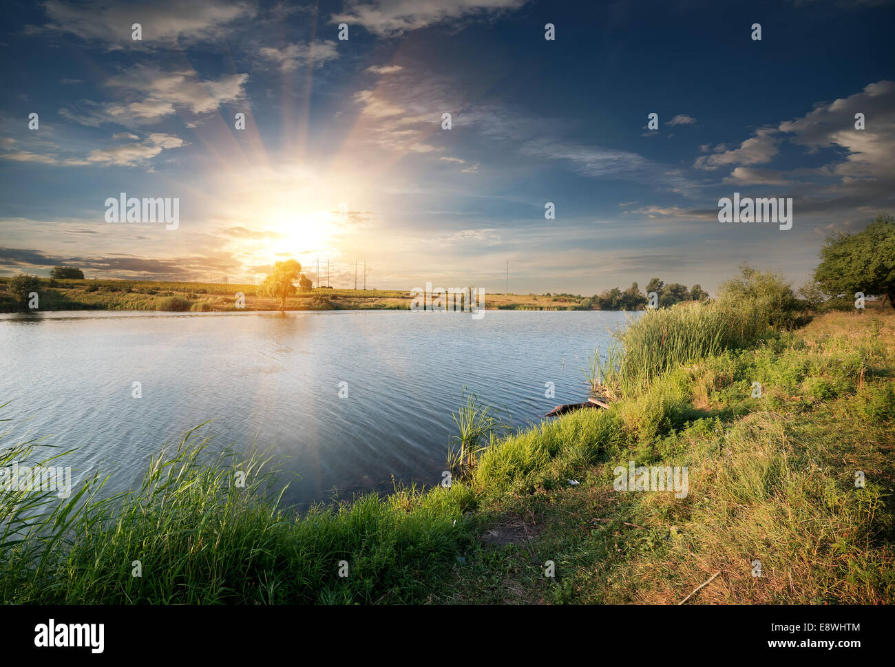 Fiume calmo ed erba verde di sera Foto Stock