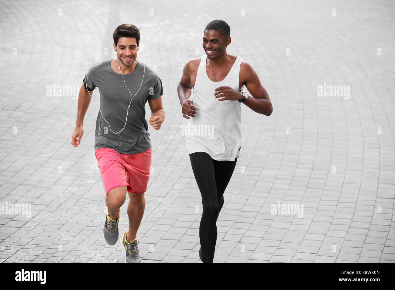 Gli uomini che corre attraverso le strade della città insieme Foto Stock