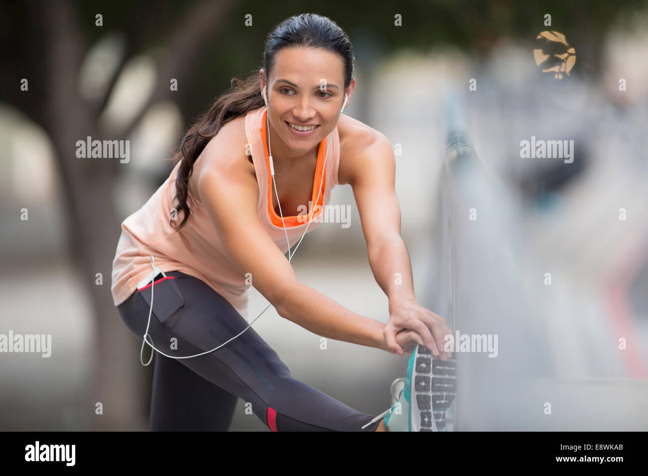 Donna stretching prima di esercitare sulla strada di città Foto Stock