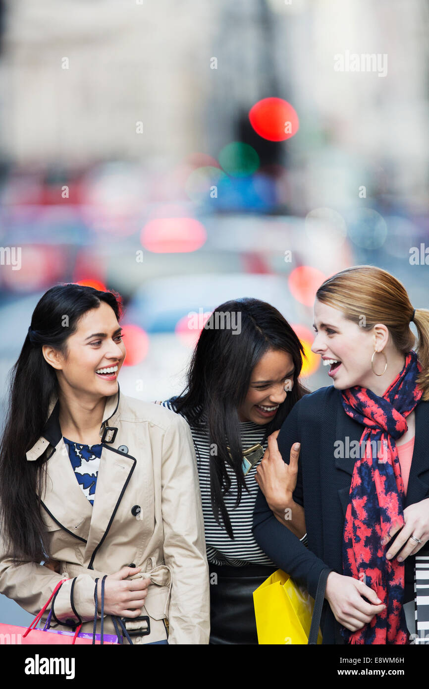 Donne in cammino insieme lungo una strada di città Foto Stock