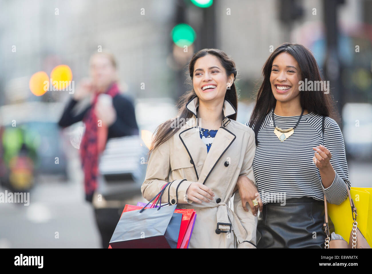 Donne in cammino insieme lungo una strada di città Foto Stock