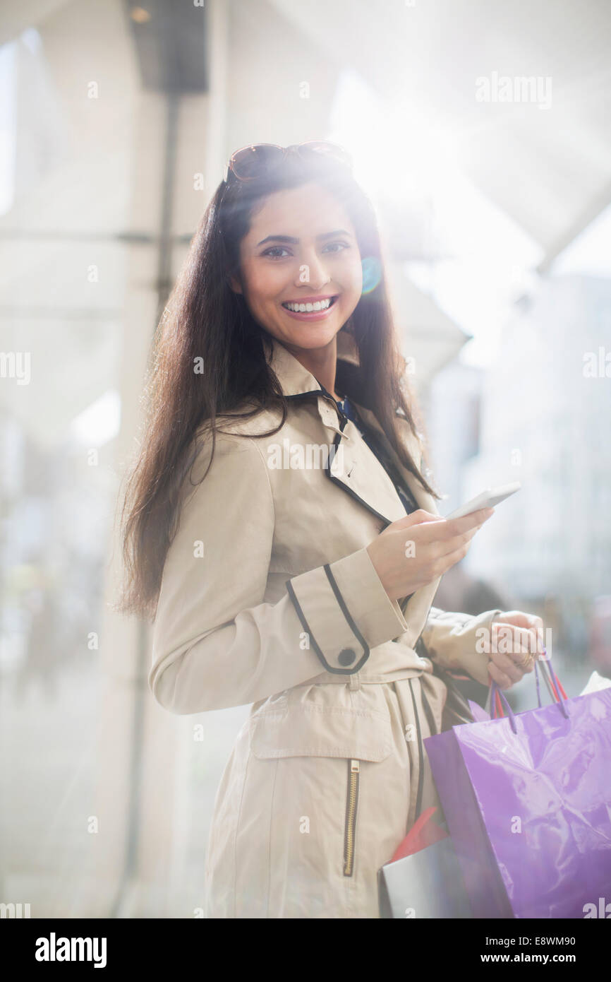 Donna che utilizza il telefono cellulare su una strada di città Foto Stock