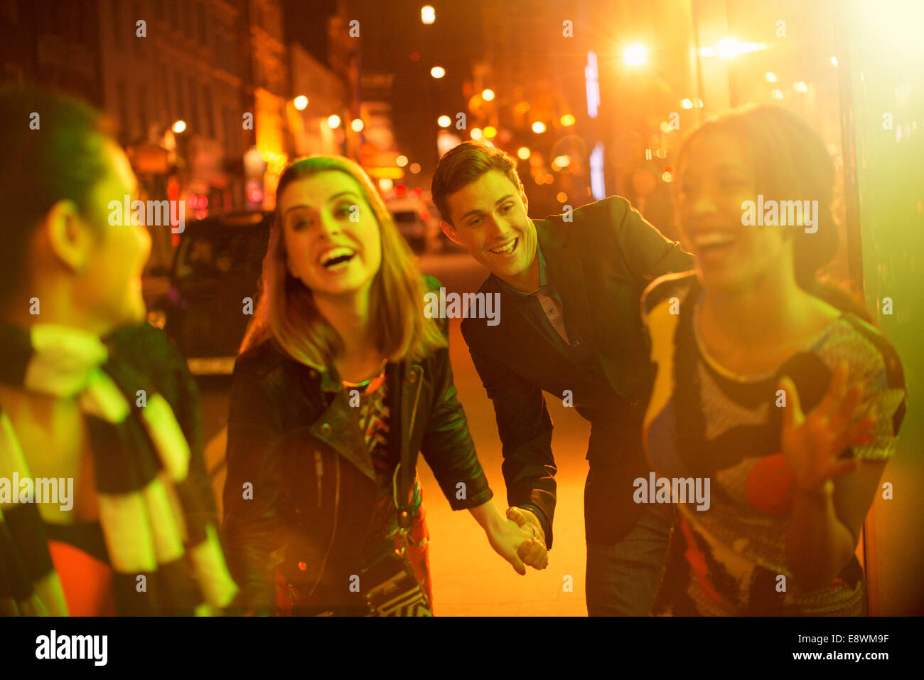Gli amici passeggiando per le strade della città insieme a notte Foto Stock