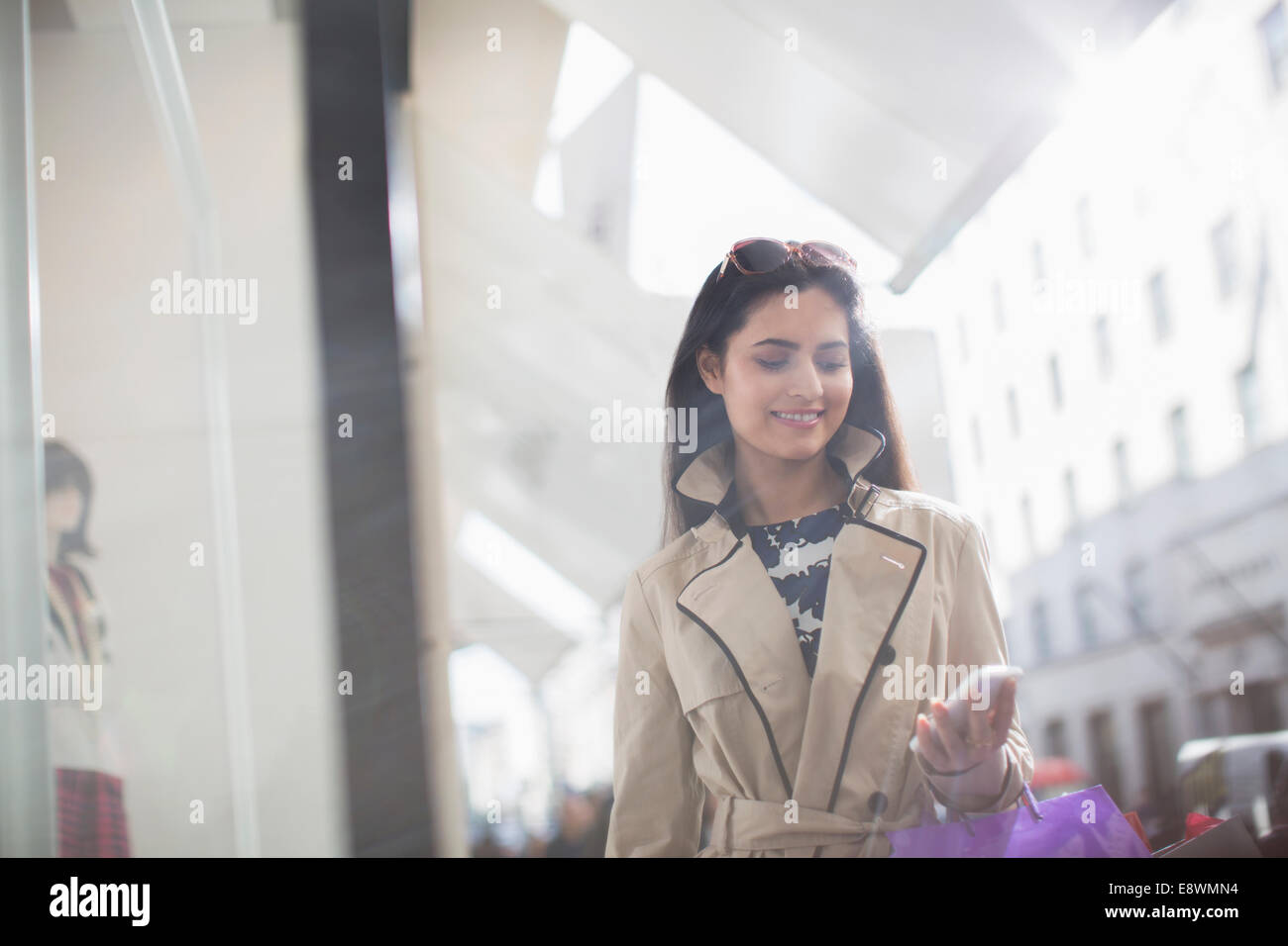 Donna che utilizza il telefono cellulare su una strada di città Foto Stock