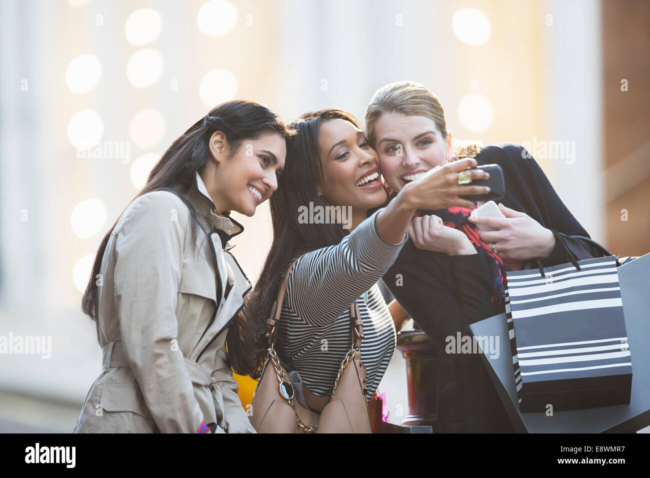 Gli amici di parlare foto con telefono cellulare insieme sulla strada di città Foto Stock