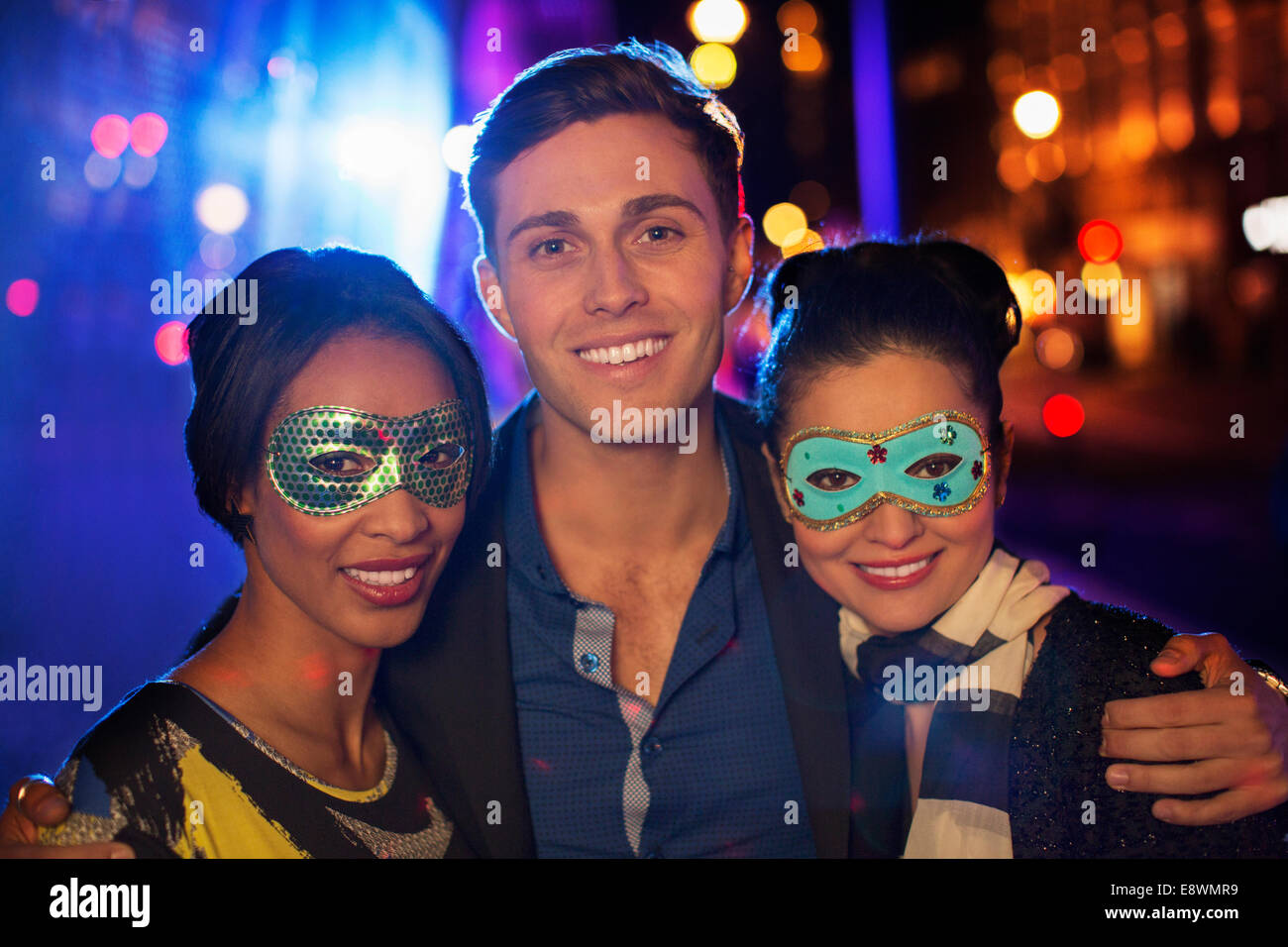 Gli amici di sorridere insieme sulla via della città di notte Foto Stock