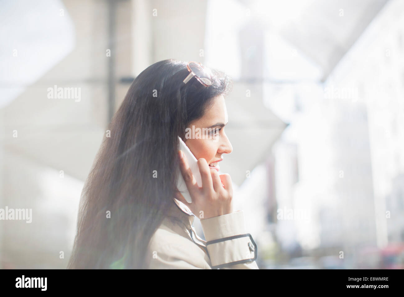 Donna che parla al cellulare su una strada di città Foto Stock