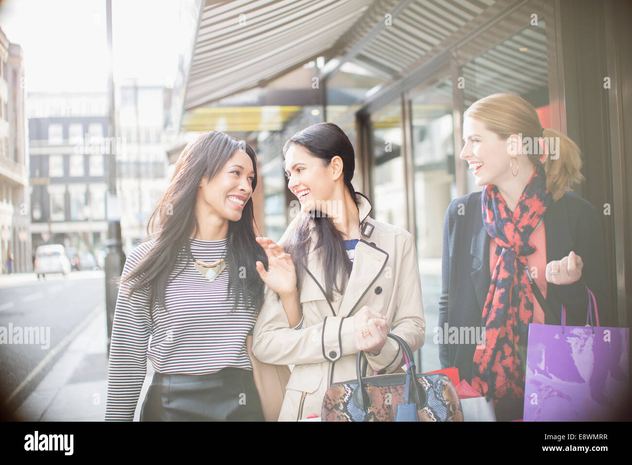 Le donne a piedi lungo una strada di città insieme Foto Stock