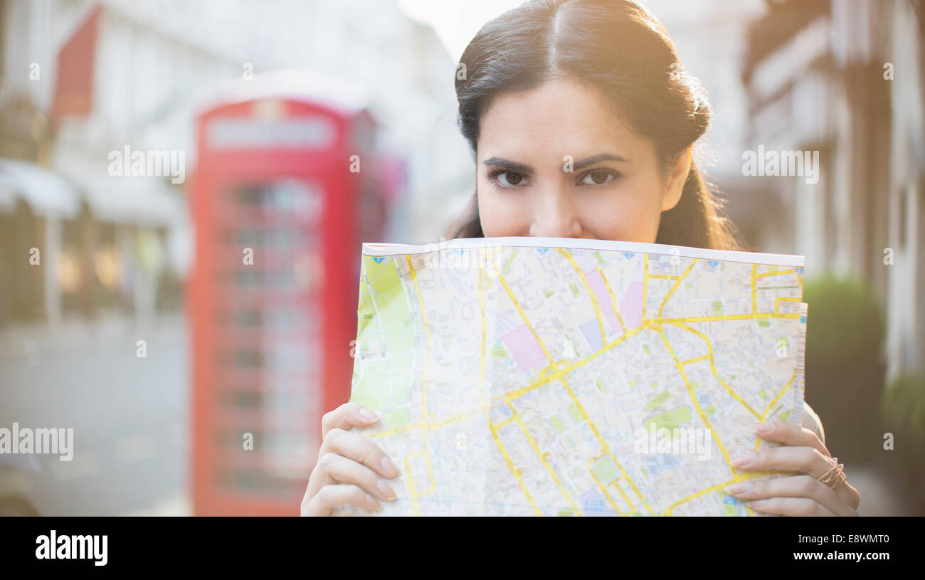 Donna che mantiene mappa sulla strada di città Foto Stock