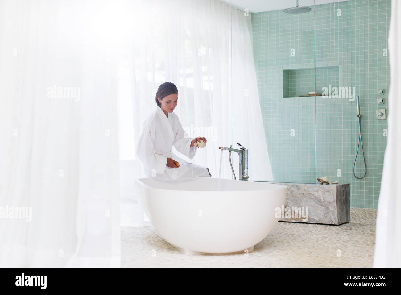 La donna in esecuzione in bagno bagno moderno Foto Stock