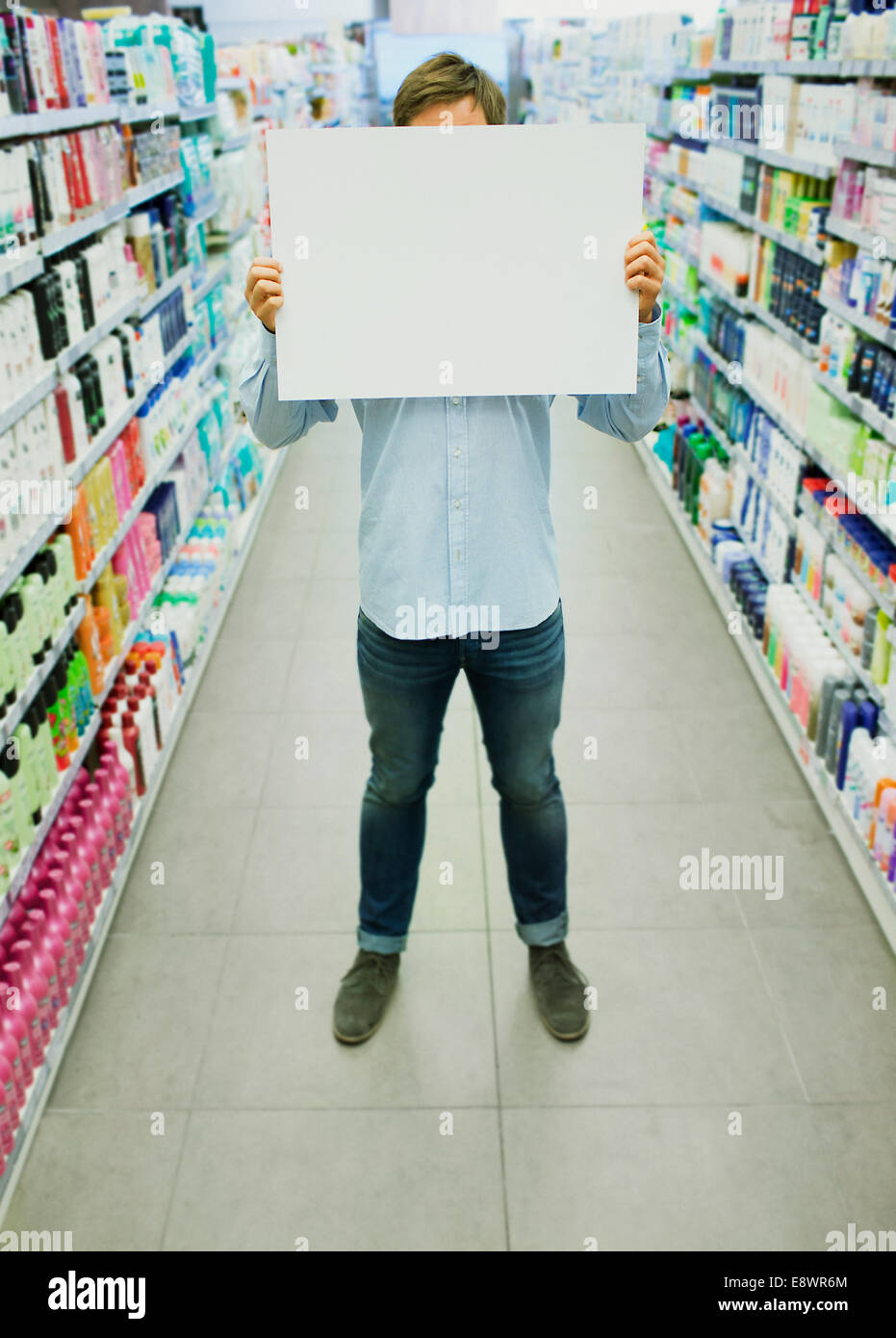 Uomo con la scheda vuota in drogheria corsia Foto Stock
