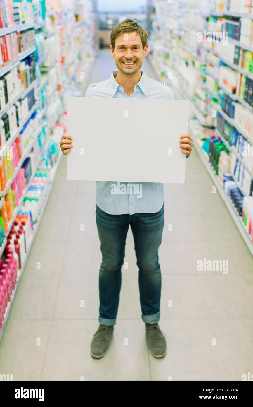 Uomo con la scheda vuota in drogheria corsia Foto Stock