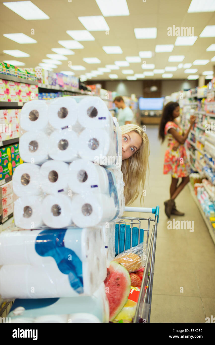 Donna piena di spinta carrello acquisti nel negozio di alimentari Foto Stock