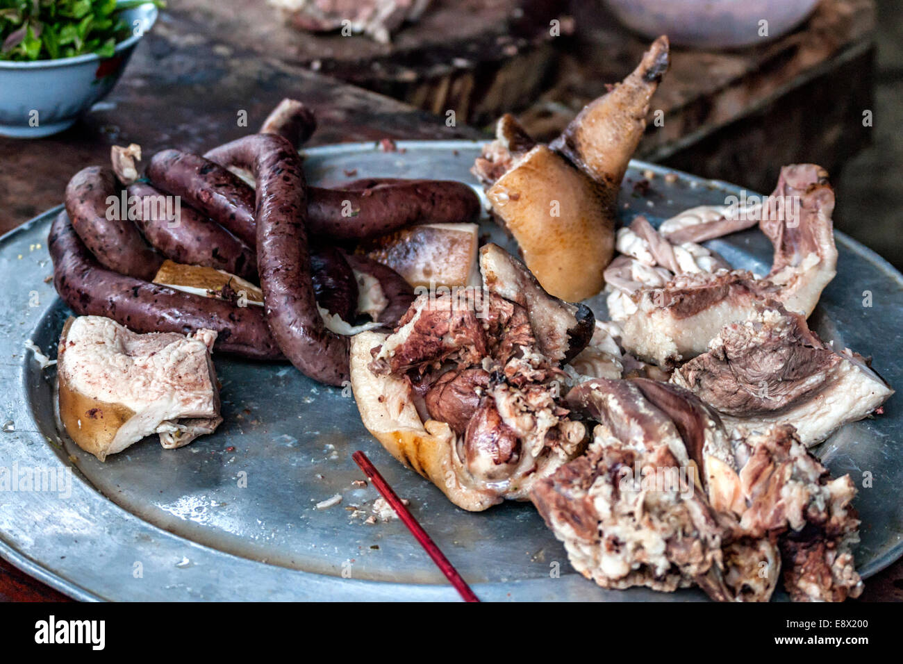 Le carni in vendita presso il ristorante sul mercato di domenica, salsiccia di sangue viene scisso testa del maiale. Foto Stock