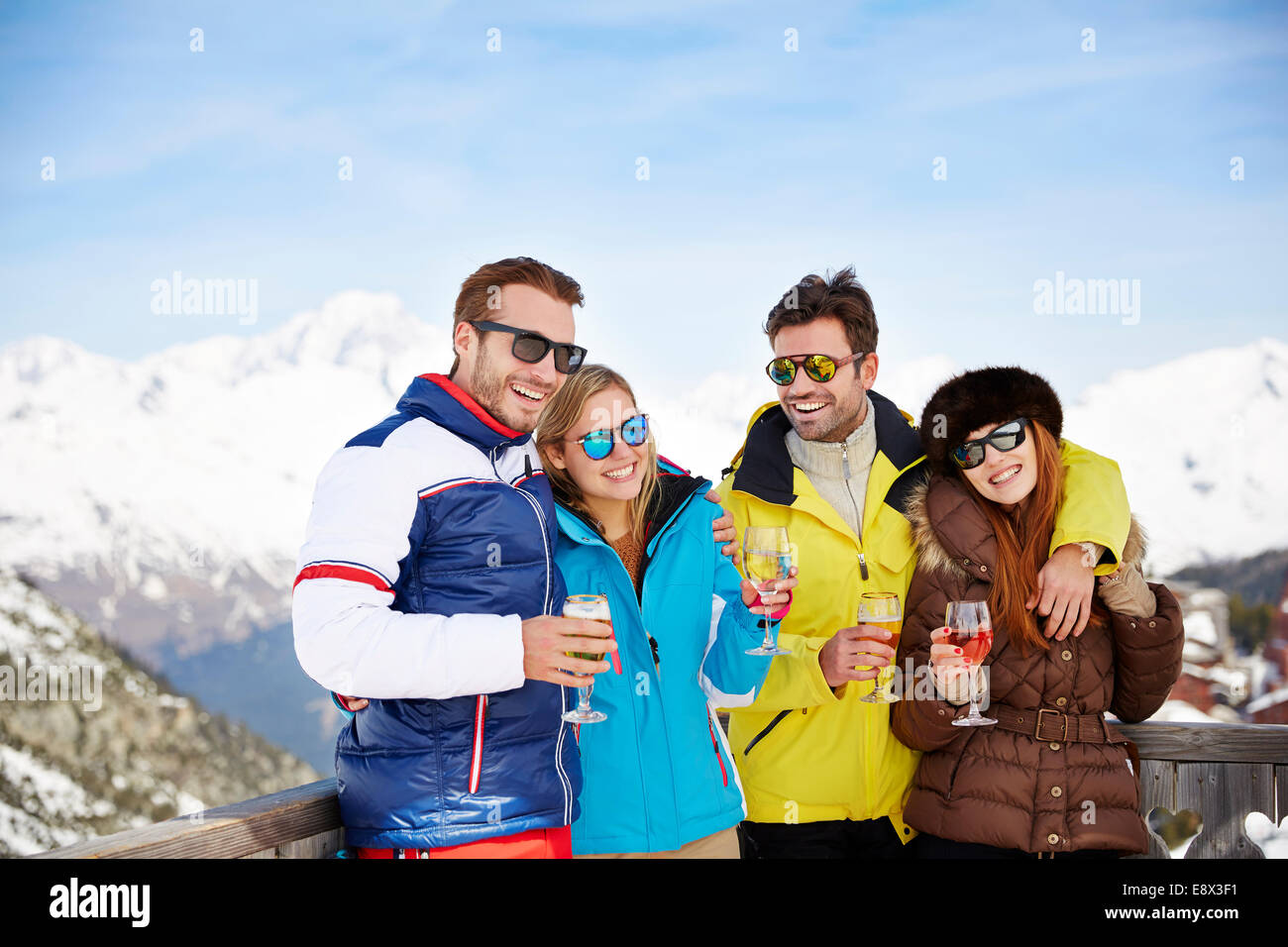 Amici celebrando con bevande nella neve Foto Stock