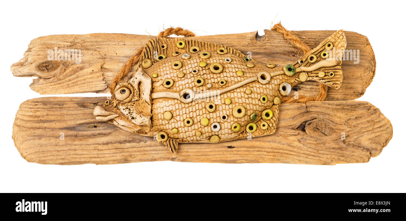 Pesce di argilla su legno stagionato isolati su sfondo bianco. Foto Stock