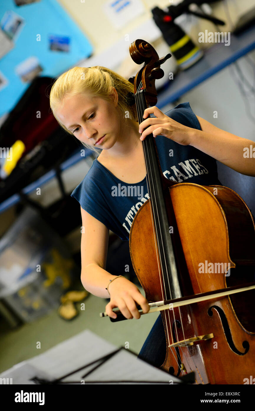 Educazione musicale di una giovane ragazza adolescente musicista ripassando violoncello giocando classe lezione workshop a Aberystwyth MusicFest 2014 Foto Stock