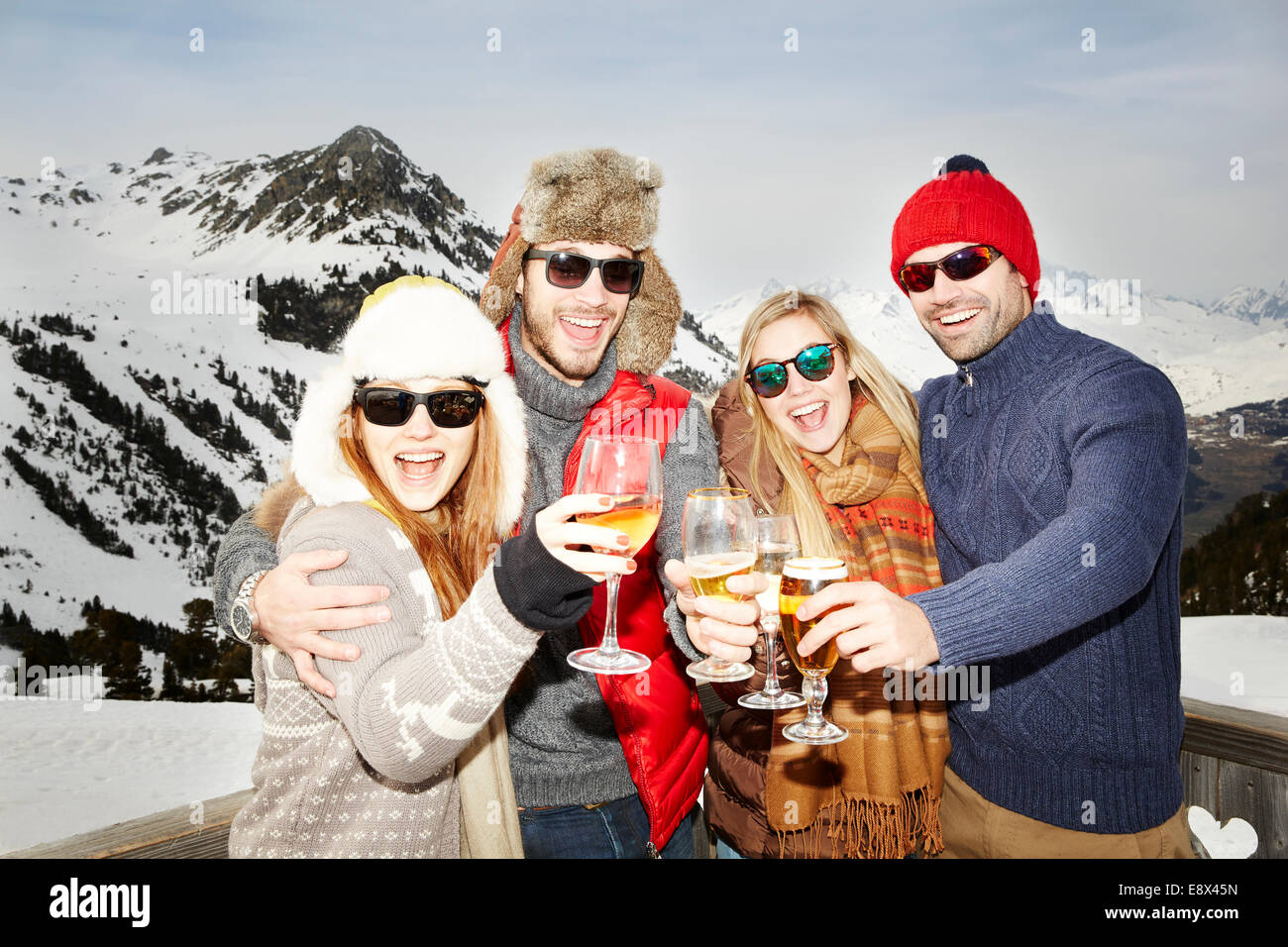 Coppie che festeggiavano con bevande nella neve Foto Stock