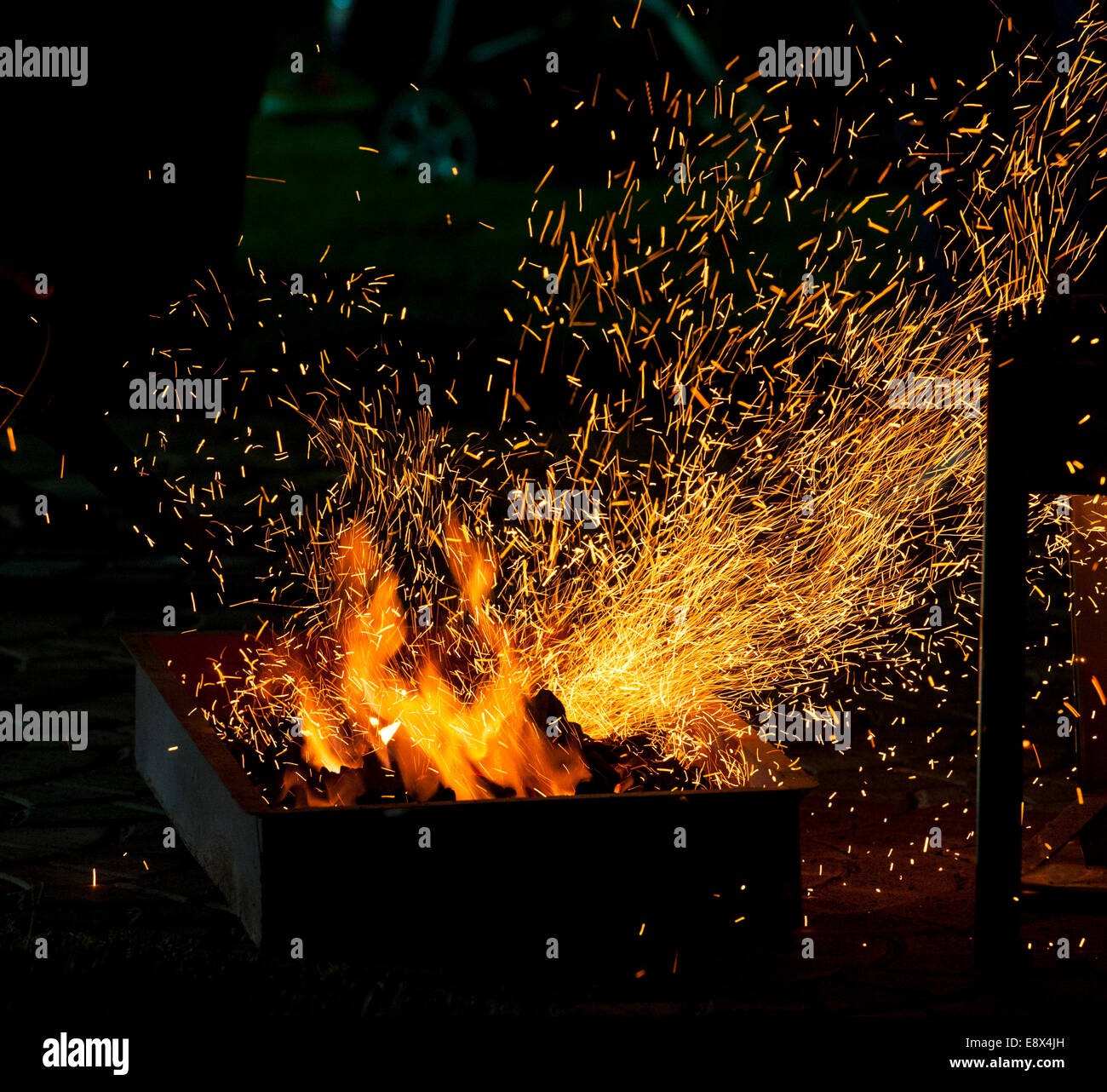 Piccolo barbecue sul fuoco con la combustione di carbonella e scintille volanti Foto Stock