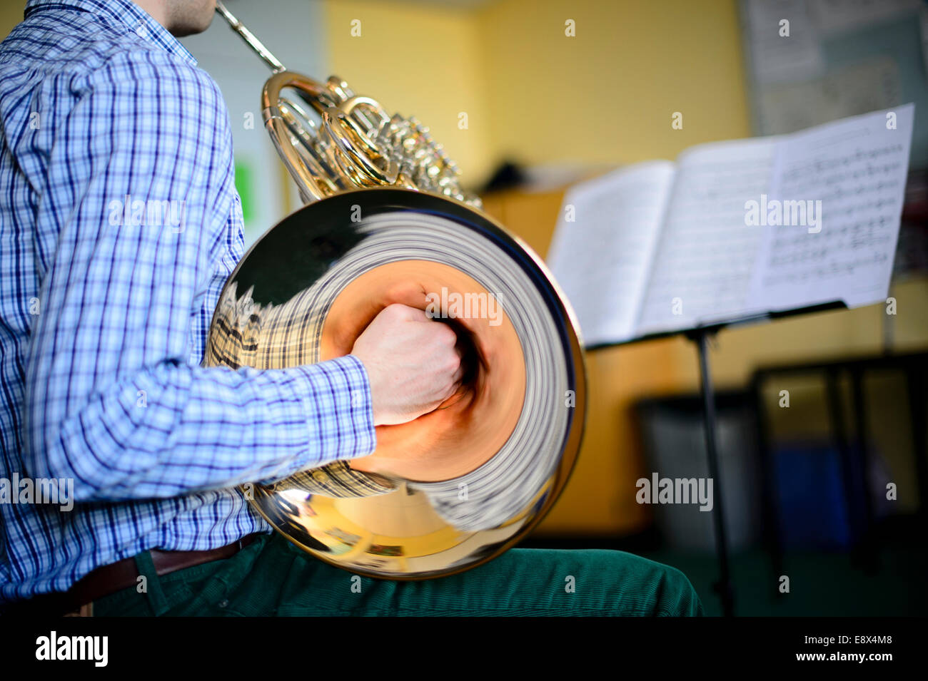 Un giovane adolescente musicista maschio pratica riproduzione di corno francese, parte di Aberystwyth Arts Center's MusicFest 2014 Foto Stock