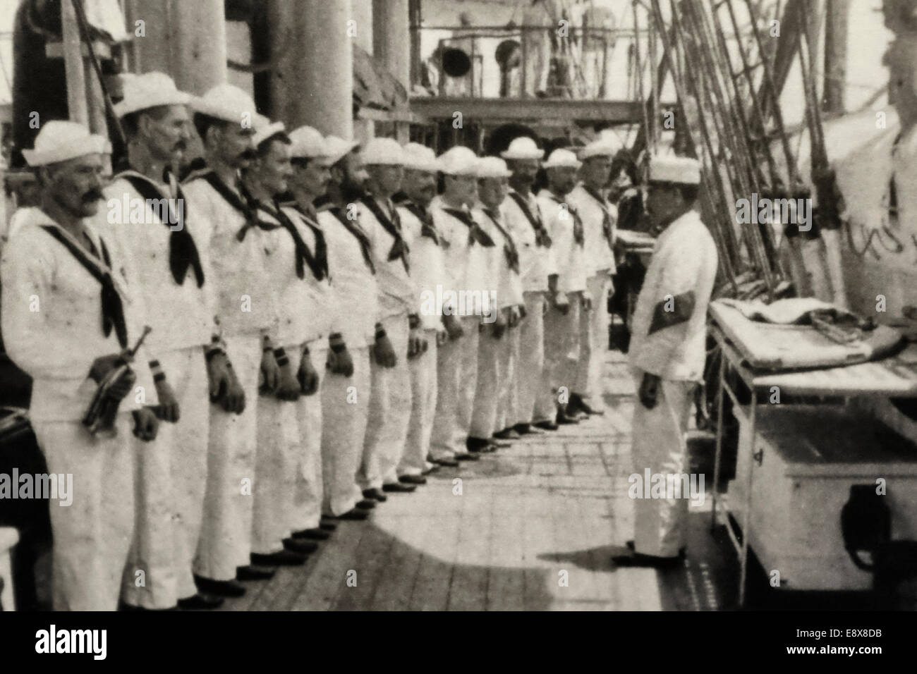 Tutti gli occhi sul capo, come marinai pronti per l'ispezione a bordo di una nave da guerra americana al volgere del secolo, circa 1900 Foto Stock