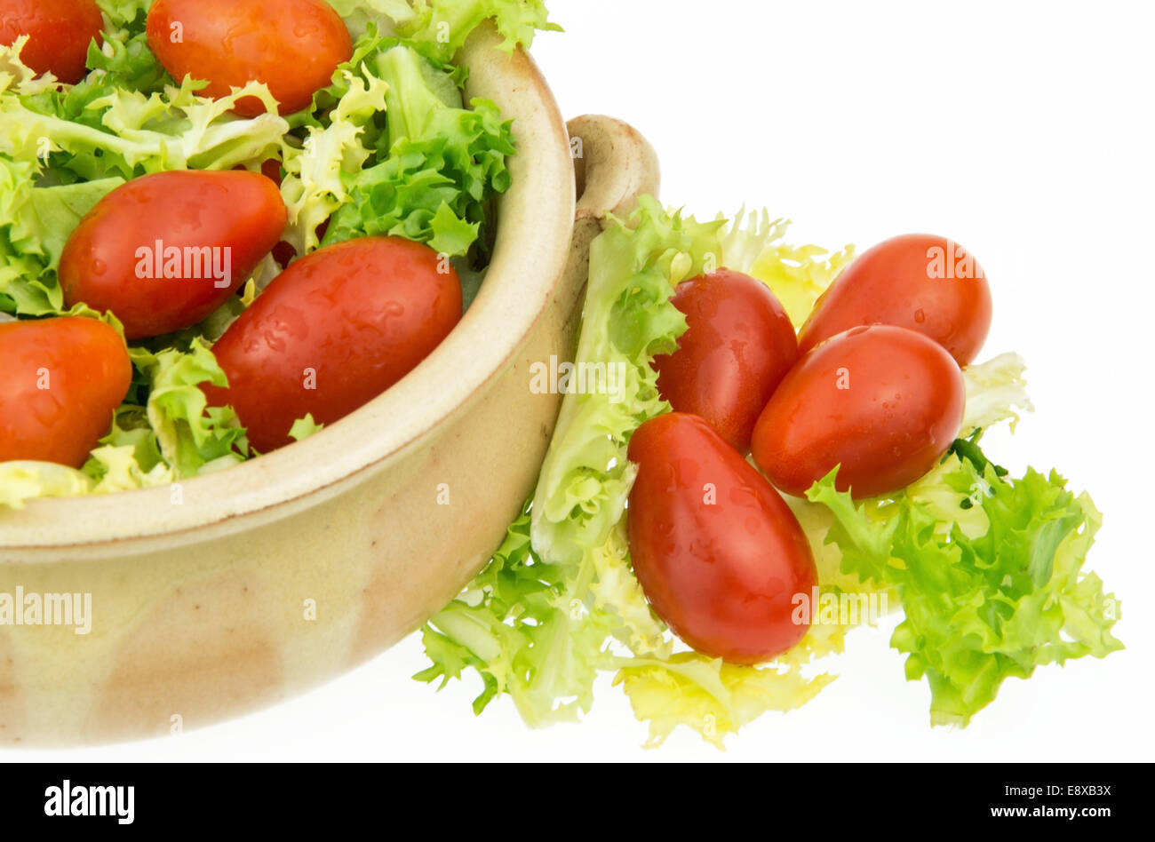 Uva pomodorini con insalata verde su sfondo bianco Foto Stock