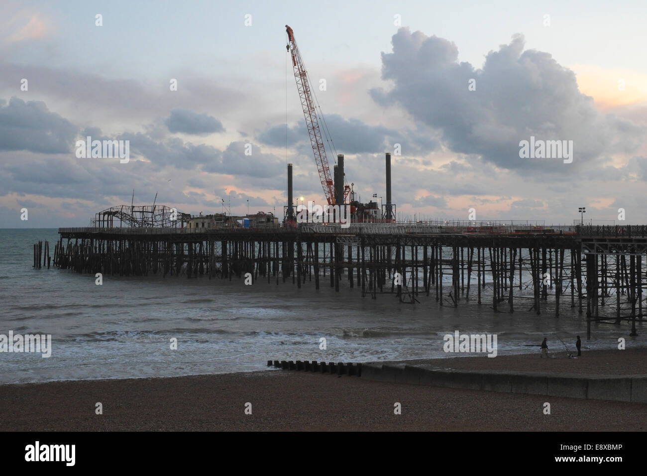 Sollevare con un martinetto la gru e la chiatta per accedere alla fine del molo di Hastings per smantellare il relitto della vecchia sala da ballo distrutto da un incendio 2010 Foto Stock