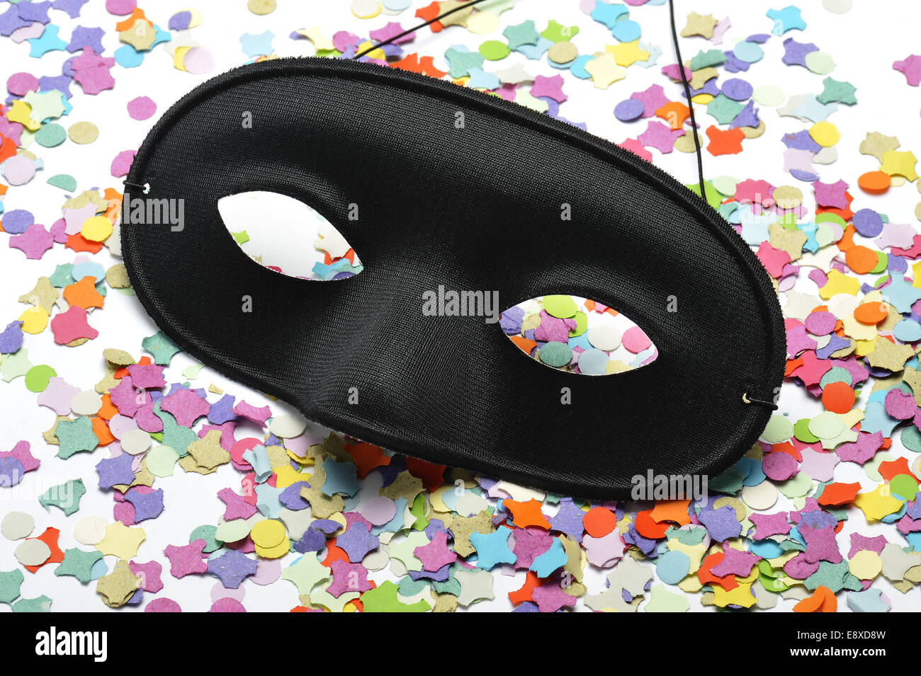 Nero maschera di Carnevale sulla colorata coriandoli Foto Stock