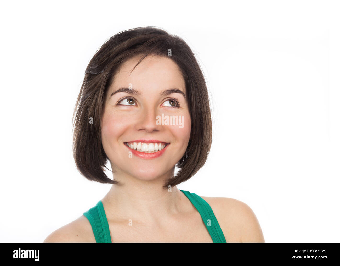 Close-up ritratto di una giovane donna sorridente guardando in alto, isolato su bianco Foto Stock