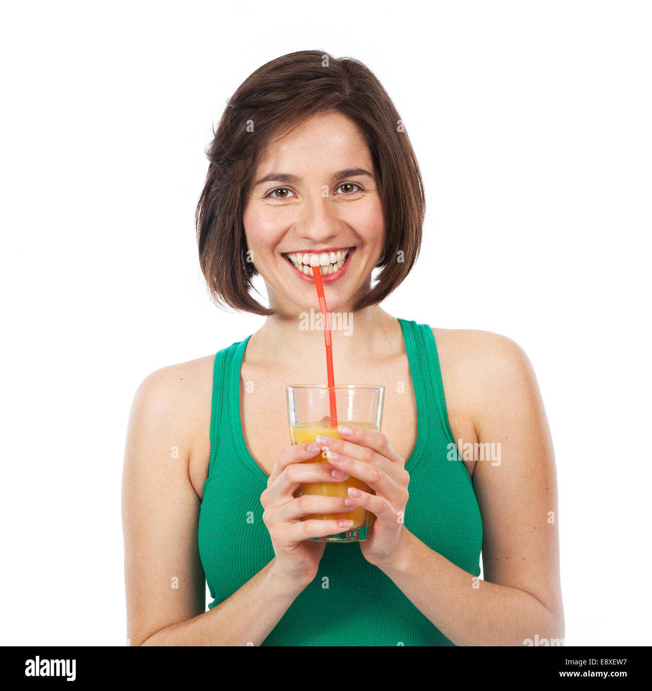 Ritratto di una giovane donna di bere un succo di arancio con una cannuccia, isolato su bianco Foto Stock