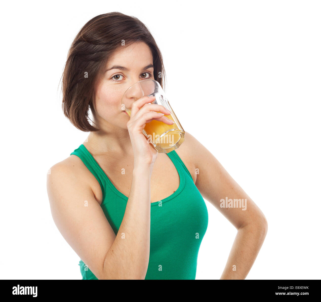 Ritratto di una giovane donna di bere un succo di arancio, isolato su bianco Foto Stock