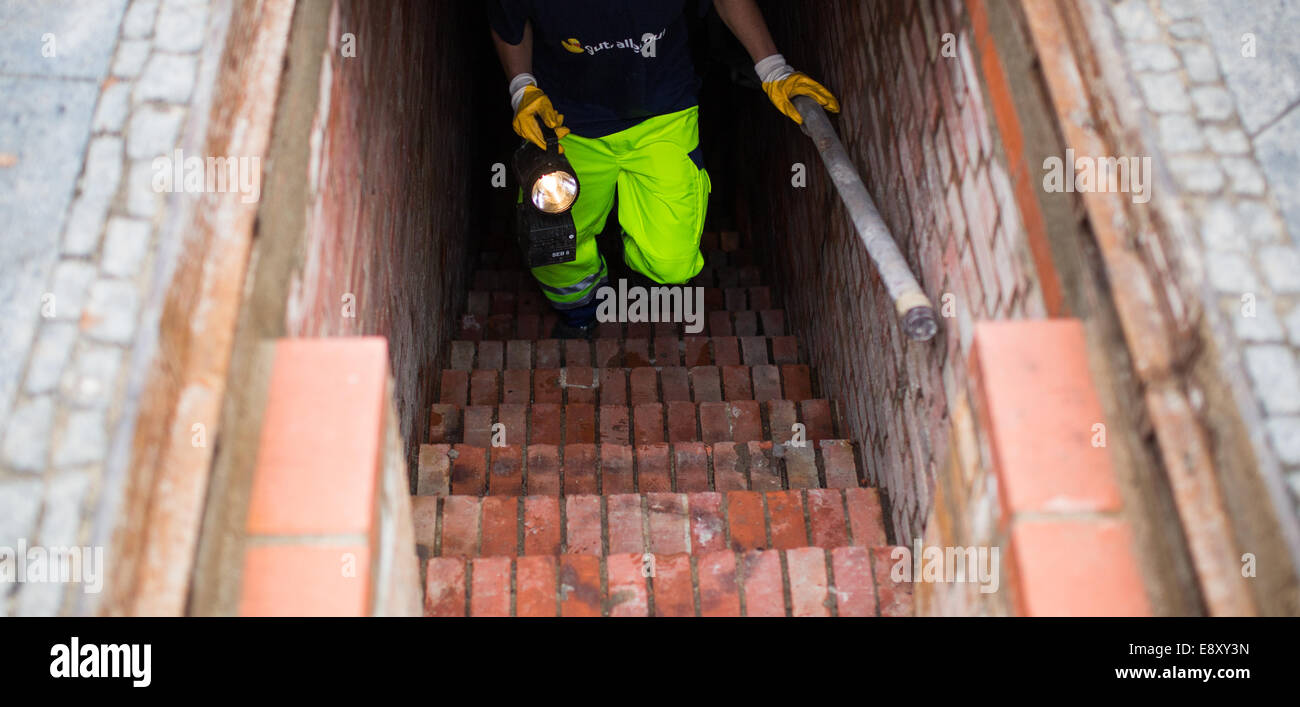 Berlino, Germania. Xvi oct, 2014. Un lavoratore passeggiate fino al di fuori della rete fognaria a Berlino, Germania, 16 ottobre 2014. La griglia, che bloccano le fognature per impedire che le persone in fuga a Berlino Ovest in sotterraneo, è ancora lì. Credito: dpa picture alliance/Alamy Live News Foto Stock