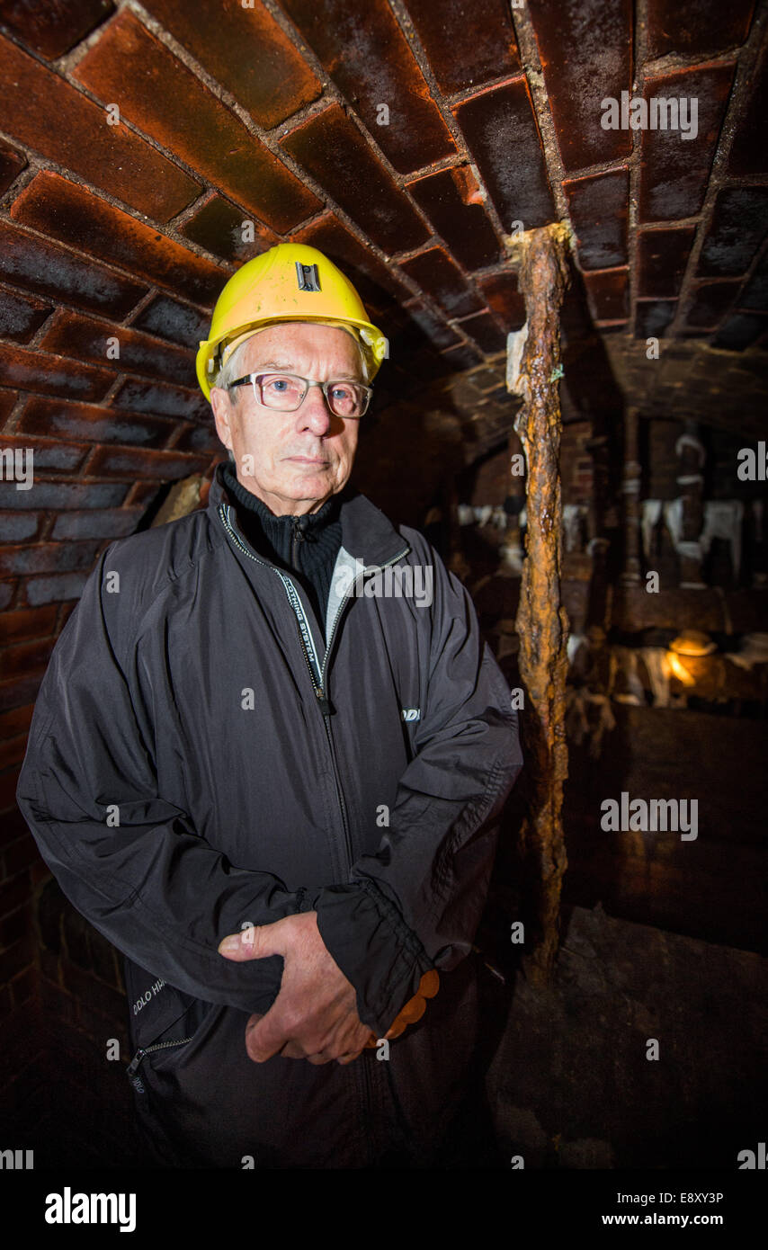 Berlino, Germania. Xvi oct, 2014. Escapee Ulrich Pfeifer (79) sorge in una fognatura a Berlino, Germania, 16 ottobre 2014. Pfeifer è stato in grado di sfuggire ad ovest con cinque studenti nel 1961. La griglia, che bloccano le fognature per impedire che le persone in fuga a Berlino Ovest in sotterraneo, è ancora lì. Credito: dpa picture alliance/Alamy Live News Foto Stock